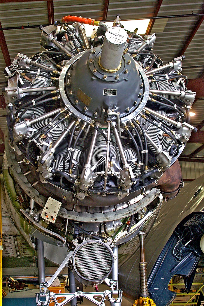 A rare photo of a rebuilt radial aircraft engine being installed on a C-47 Skytrain plane.